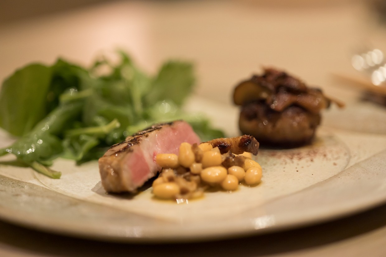 今帰仁アグーの豚肩グリルに、食感の良い大豆を合わせて。右はカカオで香りを付けたアグーのハンバーグ。